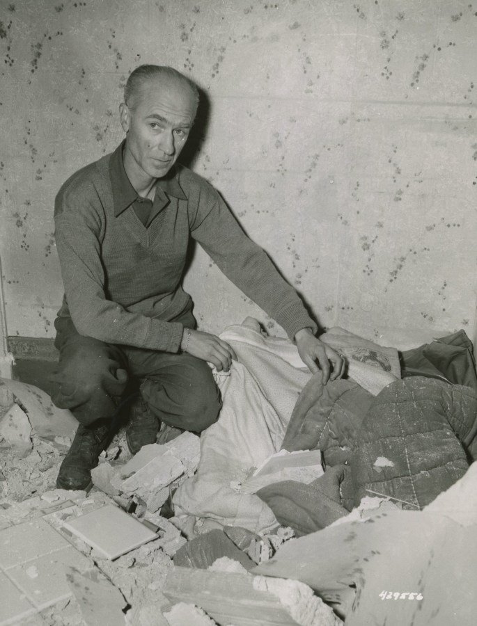 Ernie Pyle looking at his bed from which he had just left to watch the bombing when the roof fell on it. Nettuno Area Italy March 16 1944