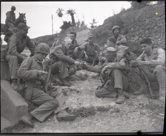 Ernie Pyle rests on the roadside with a Marine patrol April 8 1945