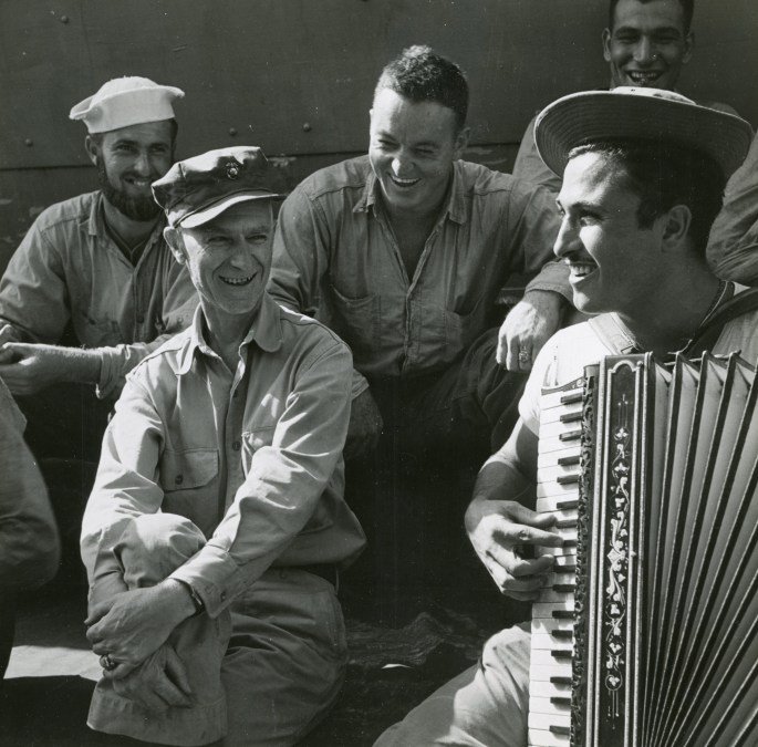 Ernie Pyle with troops listing to PFC Johnny Maturello play accordion aboard USS Charles Carroll APA 28 while enroute to Okinawa March 1945